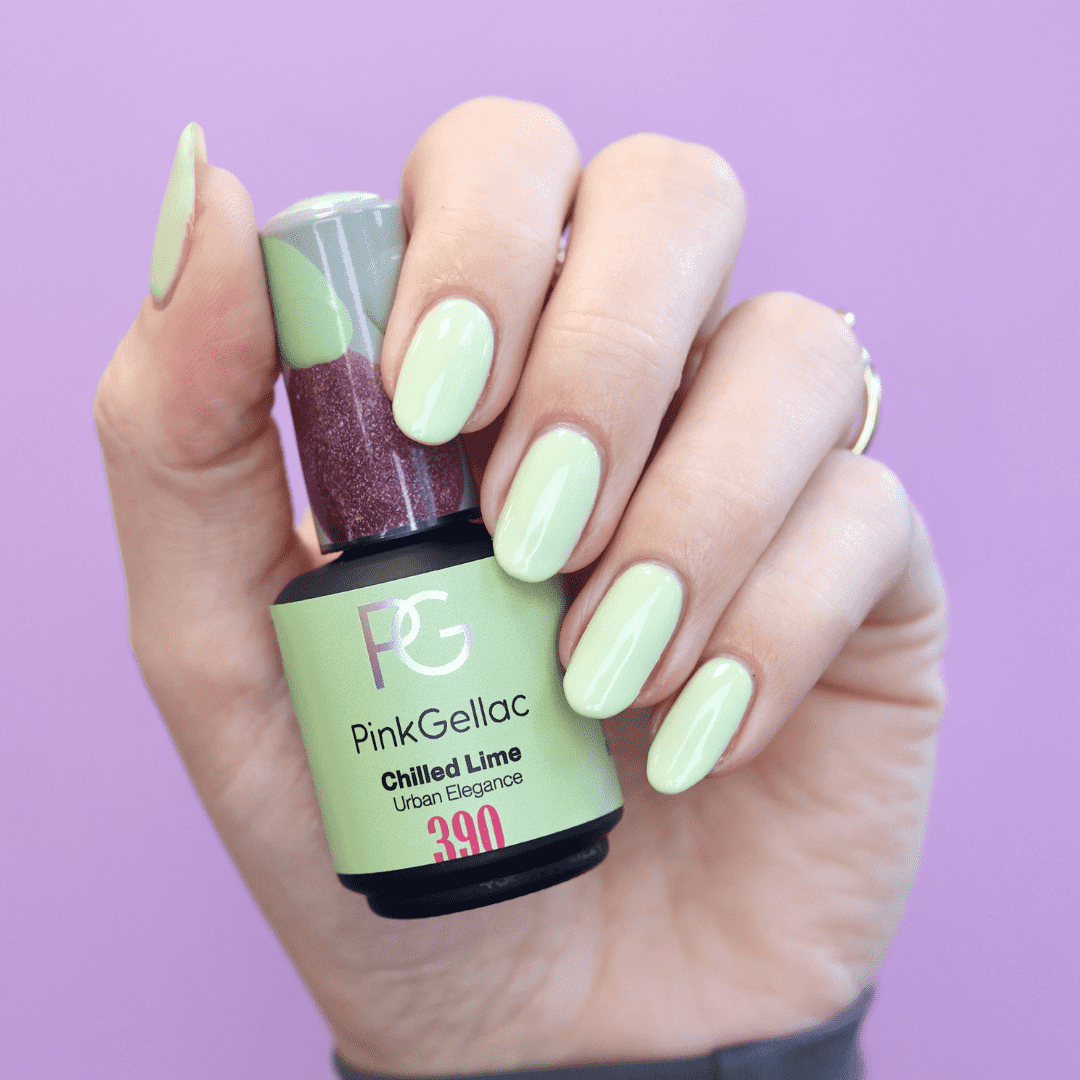 A hand with mint green nail polish holds a bottle of PinkGellac Chilled Lime nail polish against a lilac background.