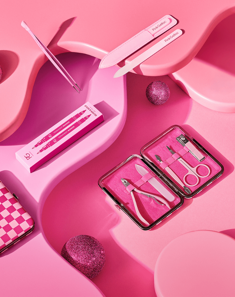 Pink nail care set with nail clipper, scissors, files and tweezers on a wavy pink background with glitter decoration.