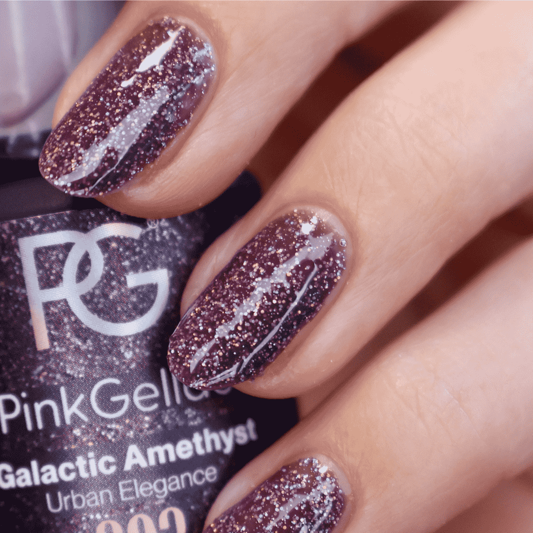 A close-up of fingers with shimmering dark purple nail polish and a jar of nail polish called "Pink Gellac Galactic Amethyst" in the background.