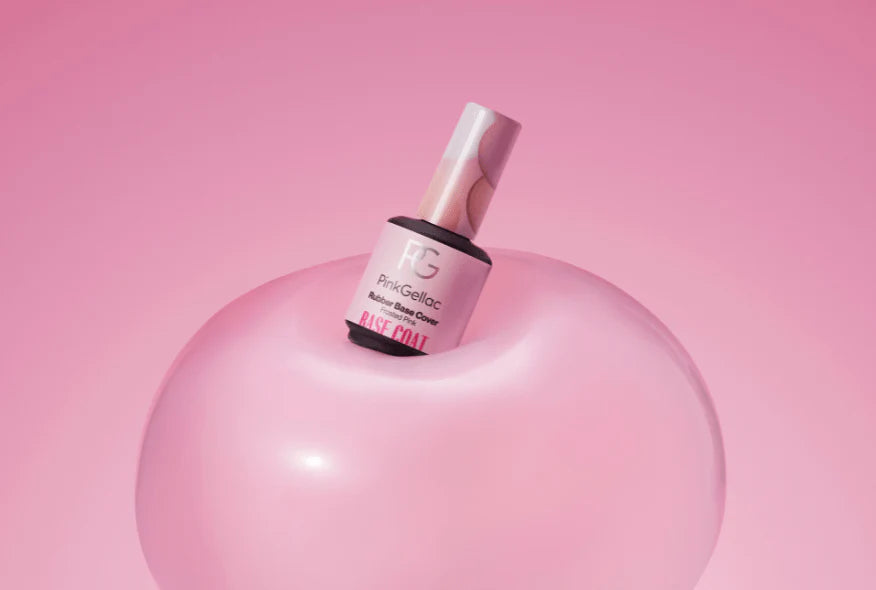 Nail polish bottle on a pink, shiny background with a pink background.