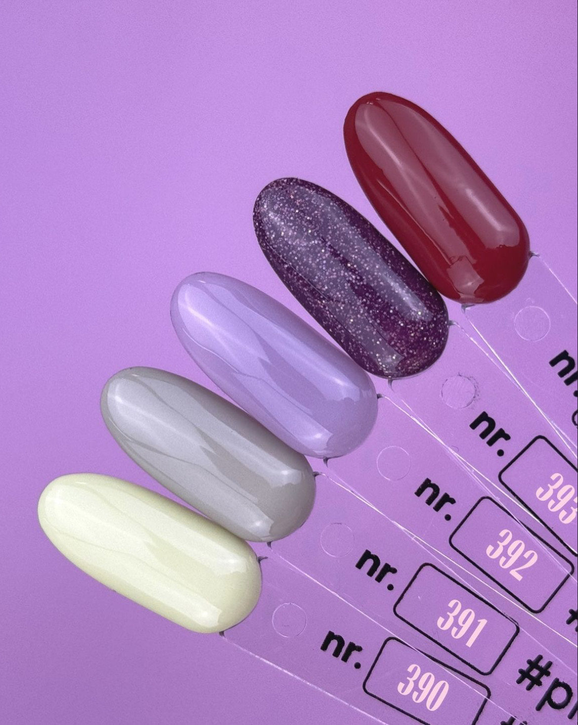 Five different colors of nail polish samples on a purple background, numbered 390 to 394.
