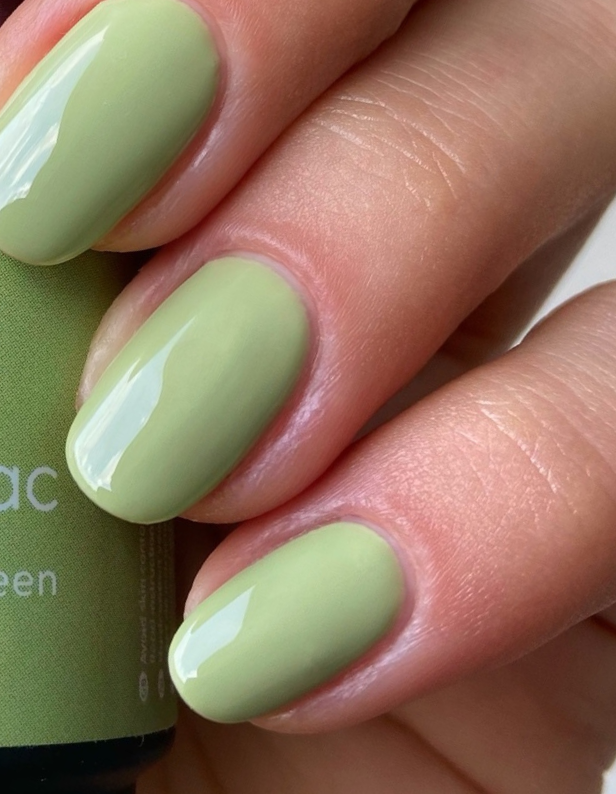 Close-up of a hand with light green painted nails.