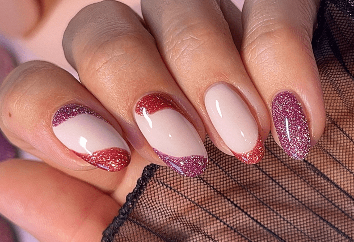 Shiny, glossy nails in pink and purple shades with glitter and an abstract shape.