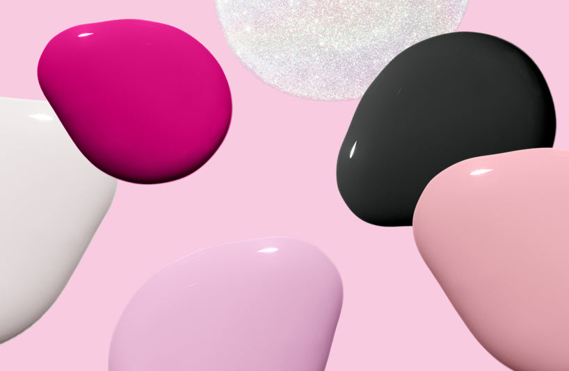 Colored nail polish drops in different shades of pink, black, white and shimmering, on a pink background.