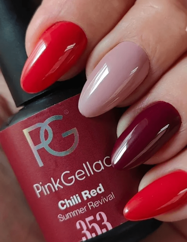 Hand with different colors of nail polish on the nails, holding a bottle of Pink Gellac nail polish in the color Chili Red.