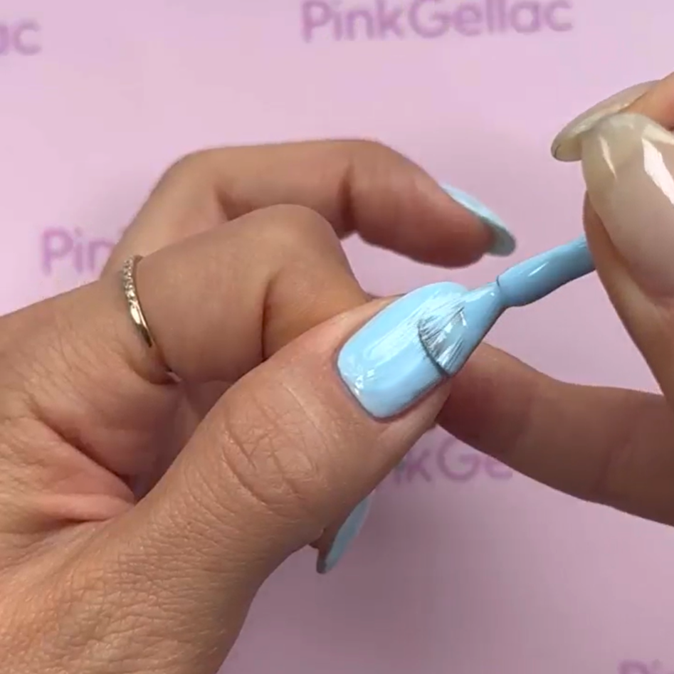 A hand is lacquered with light blue nail polish on a background of the Pink Gellac brand.