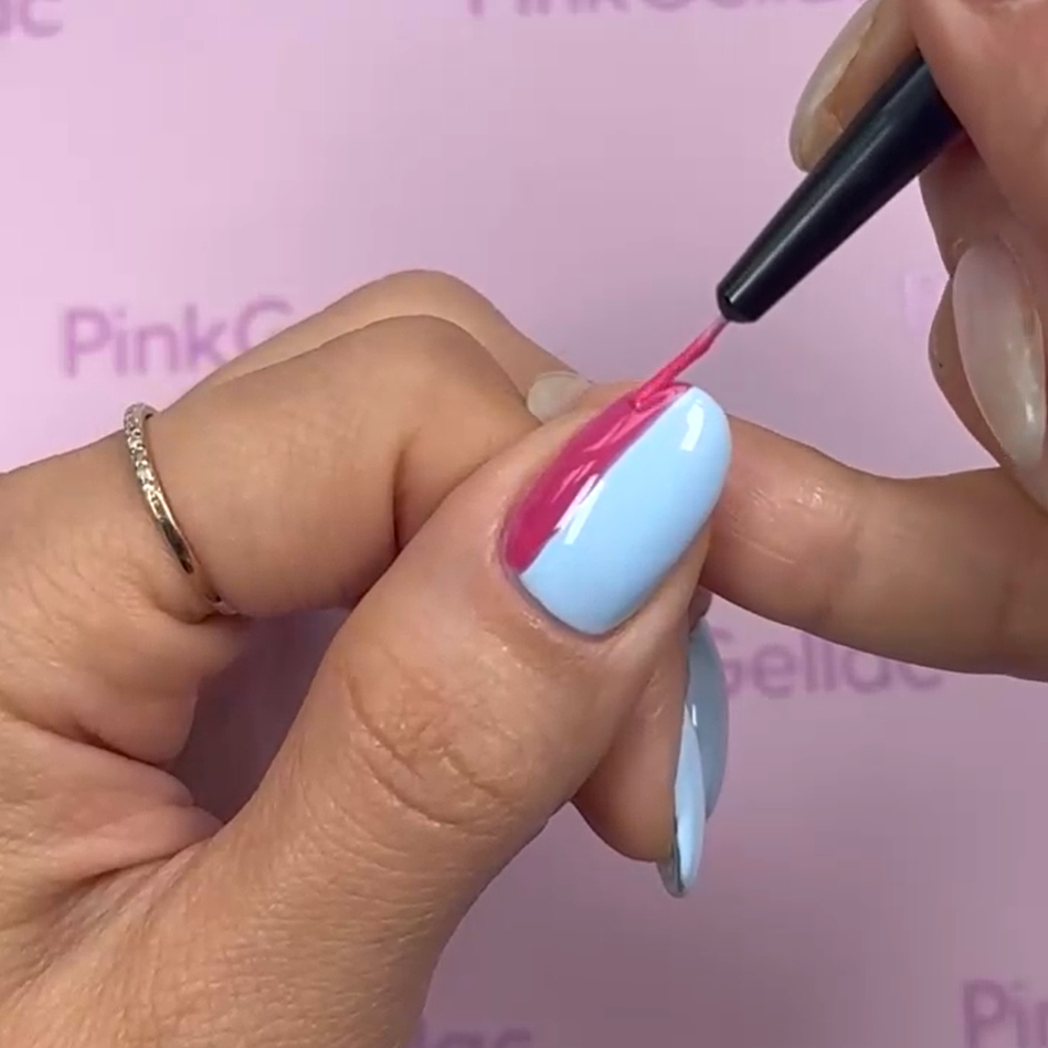 A close-up of a hand with blue nail polish, with the nail of another hand painted pink.