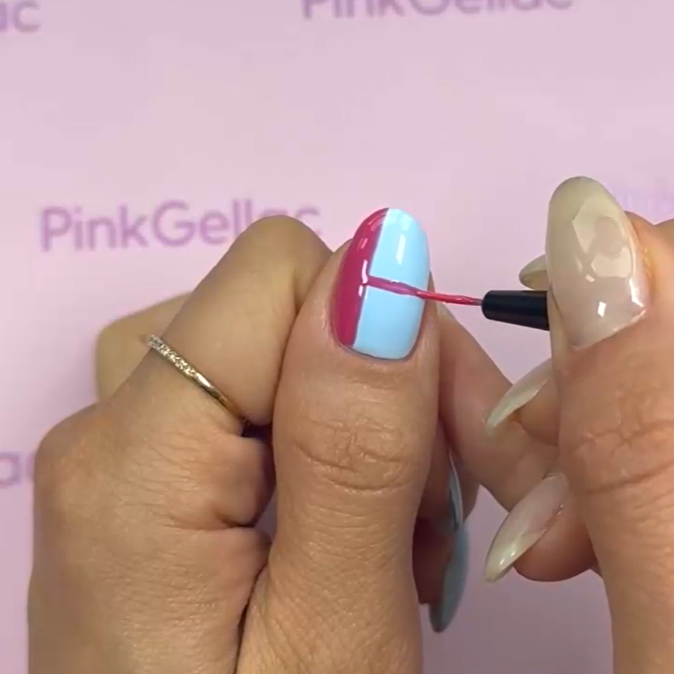 A hand using a small brush to apply a diagonal pink stripe to a light blue painted nail, with a pink background and the text "PinkGellac".