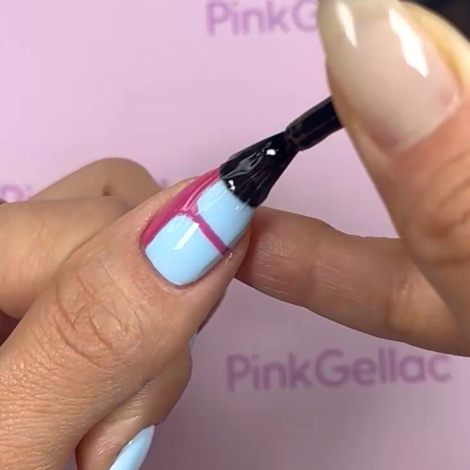A hand with light blue nail polish and pink lines is colored with a brush against a pink background with the text "Pink Gellac".