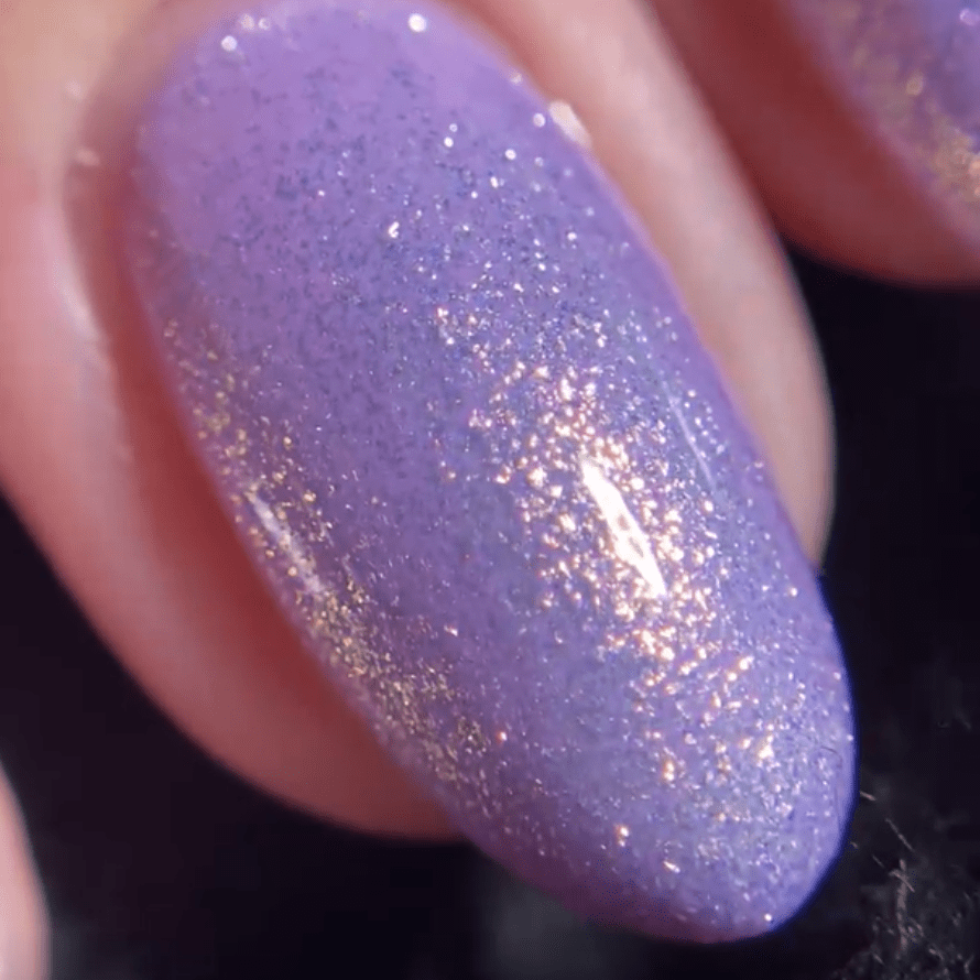 Close-up of a nail with shiny purple nail polish and subtle glitter.