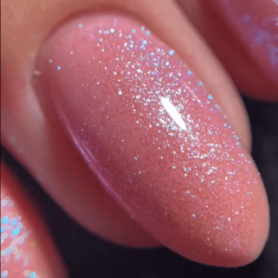 Close-up of a nail with pink glitter nail polish.