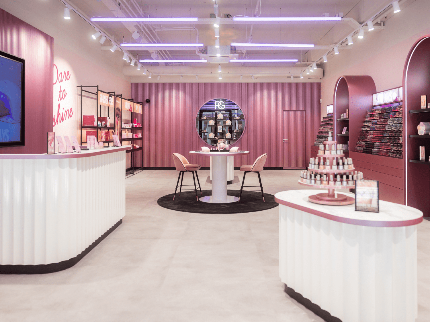 Stylish pink and white beauty salon with modern displays and accent lighting.