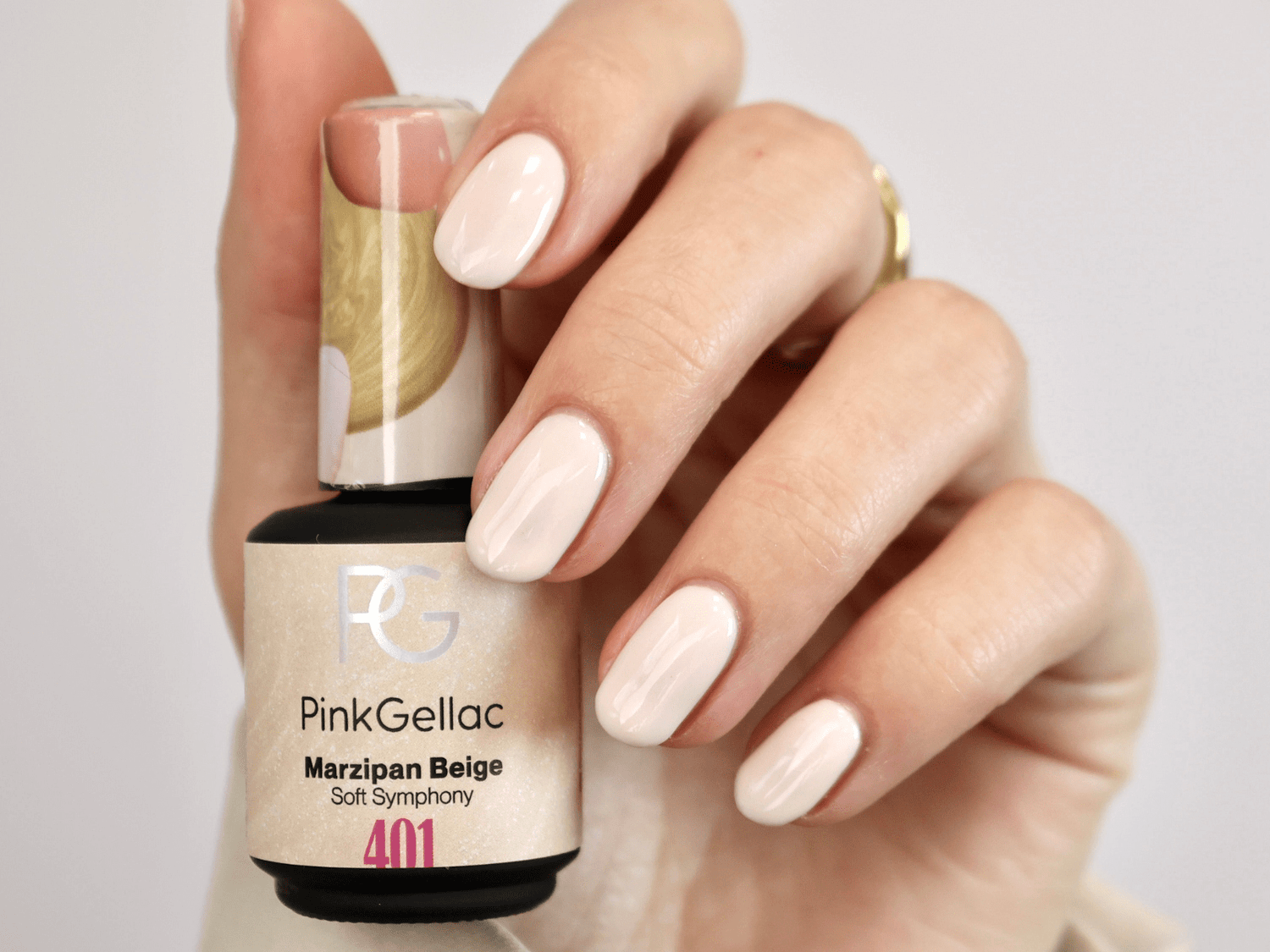 Hand with painted nails holds a bottle of Pink Gellac Marzipan Beige.