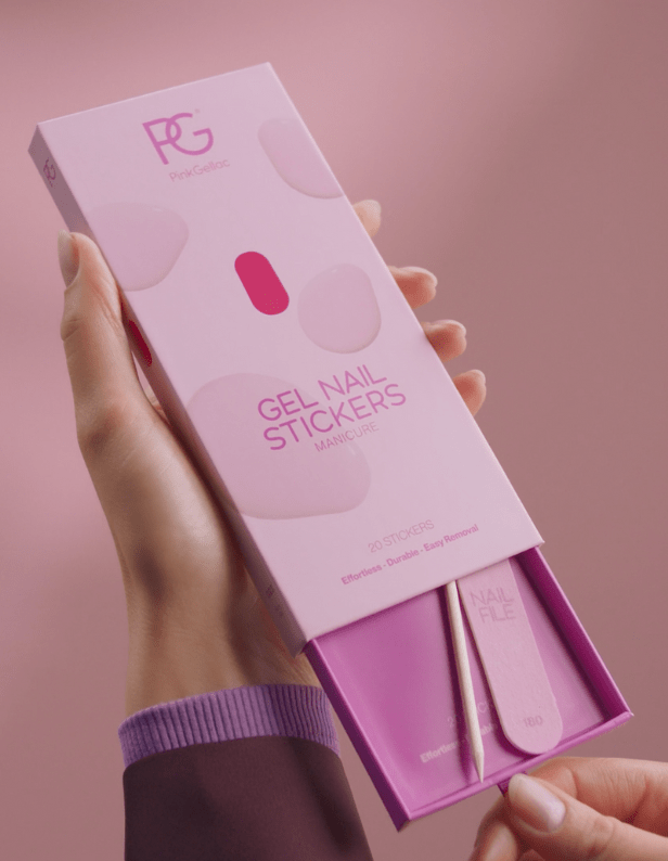 A hand holds a pink box of Pink Gellac gel nail stickers with 20 stickers, including a nail file and a wooden stick.