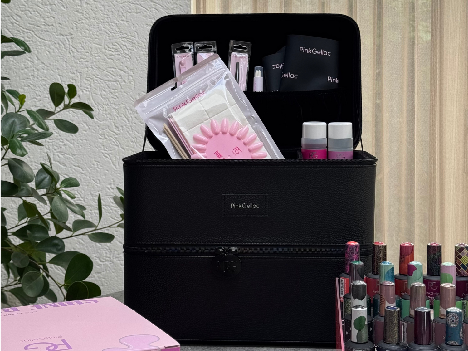 Black make-up case from Pink Gellac full of nail products, surrounded by nail polish bottles and a pink product box.
