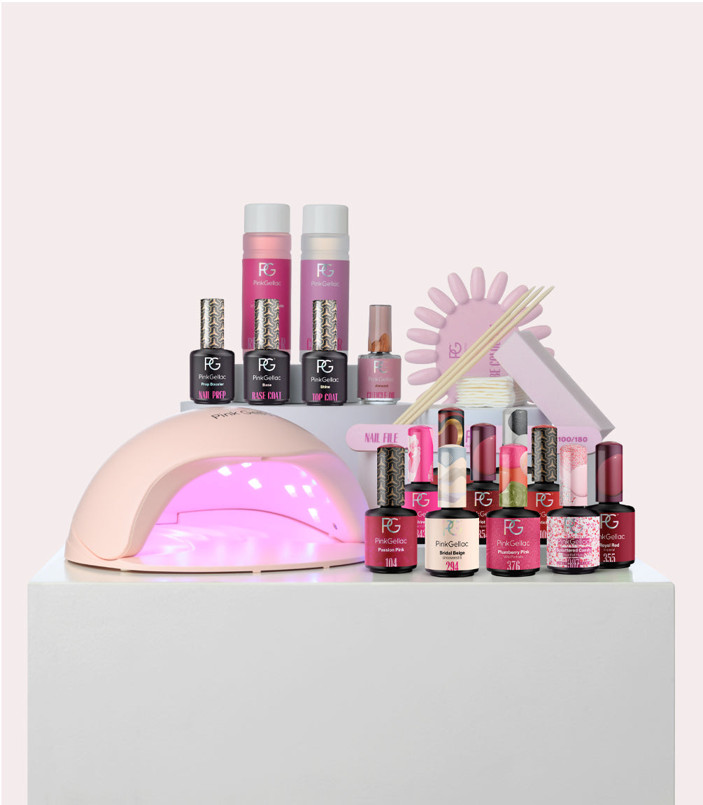 Nail care set with different colors of gel nail polish, a UV lamp, nail files, woods, cotton pads and bottles for nail preparation, base coat and top coat.