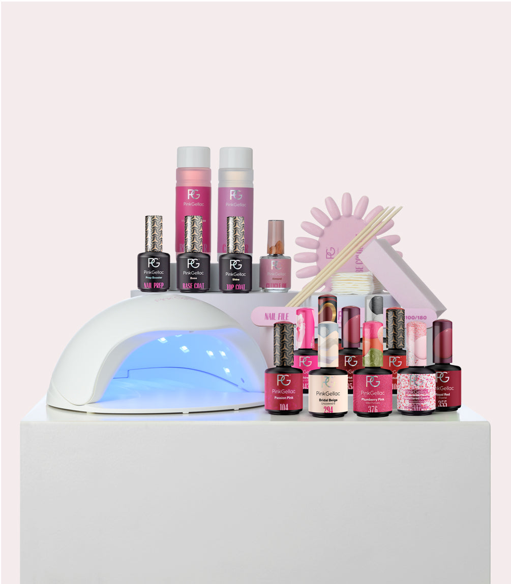 A collection of nail care products, including a UV lamp, nail polish bottles, nail files and wooden sticks, presented on a white cube.