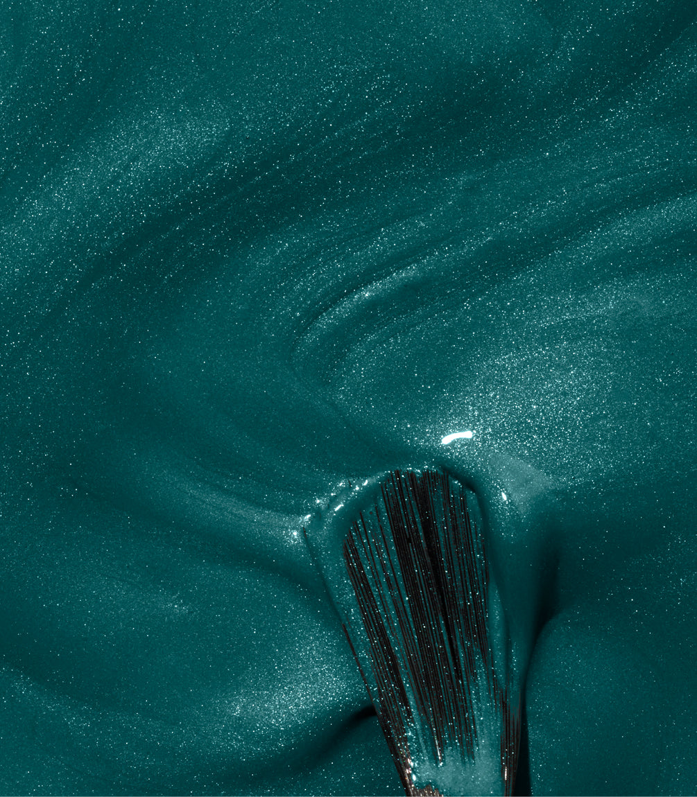 Brush in shimmering, dark green nail polish.