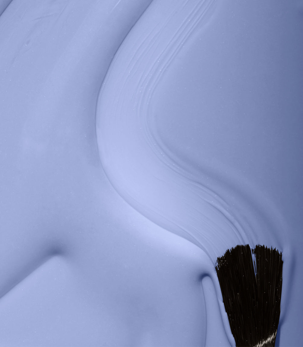 Close-up of a brush stroke with blue paint, with visible texture and bristles of the brush.