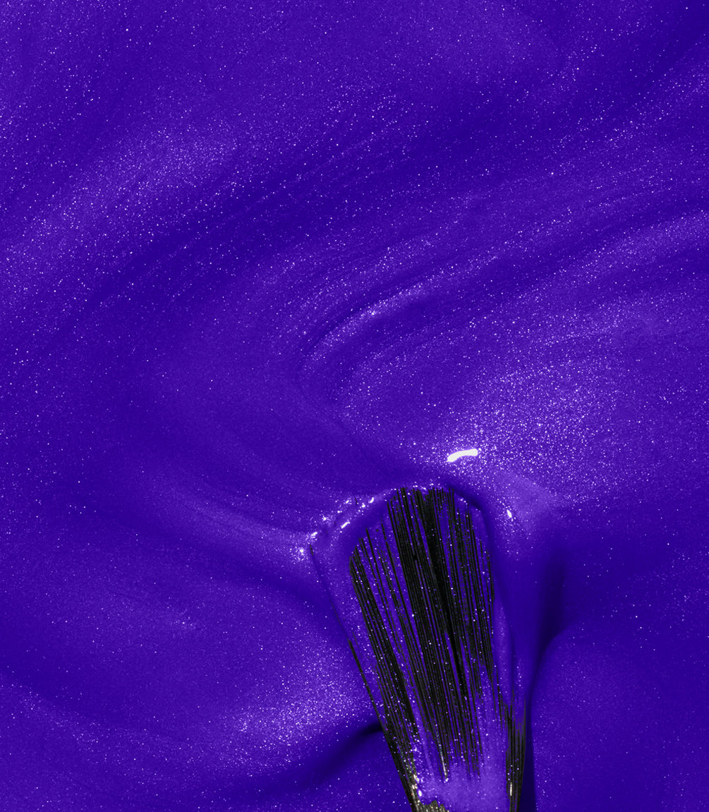 A brushstroke of purple nail polish with a shiny, shimmering texture.