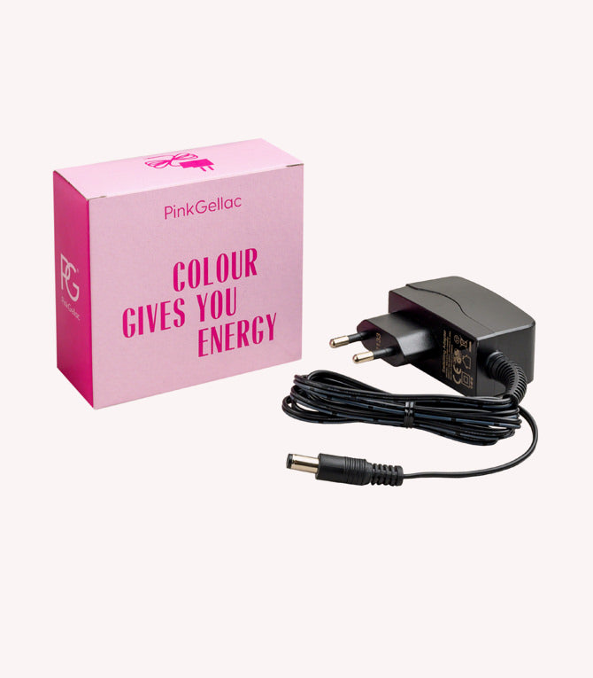 Pink box that says "Colour Gives You Energy" next to a black power adapter with plug and cable.
