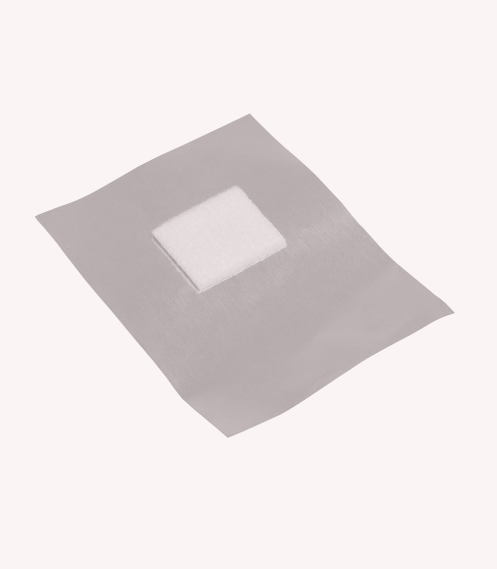 A sterile wound dressing on a beige background.