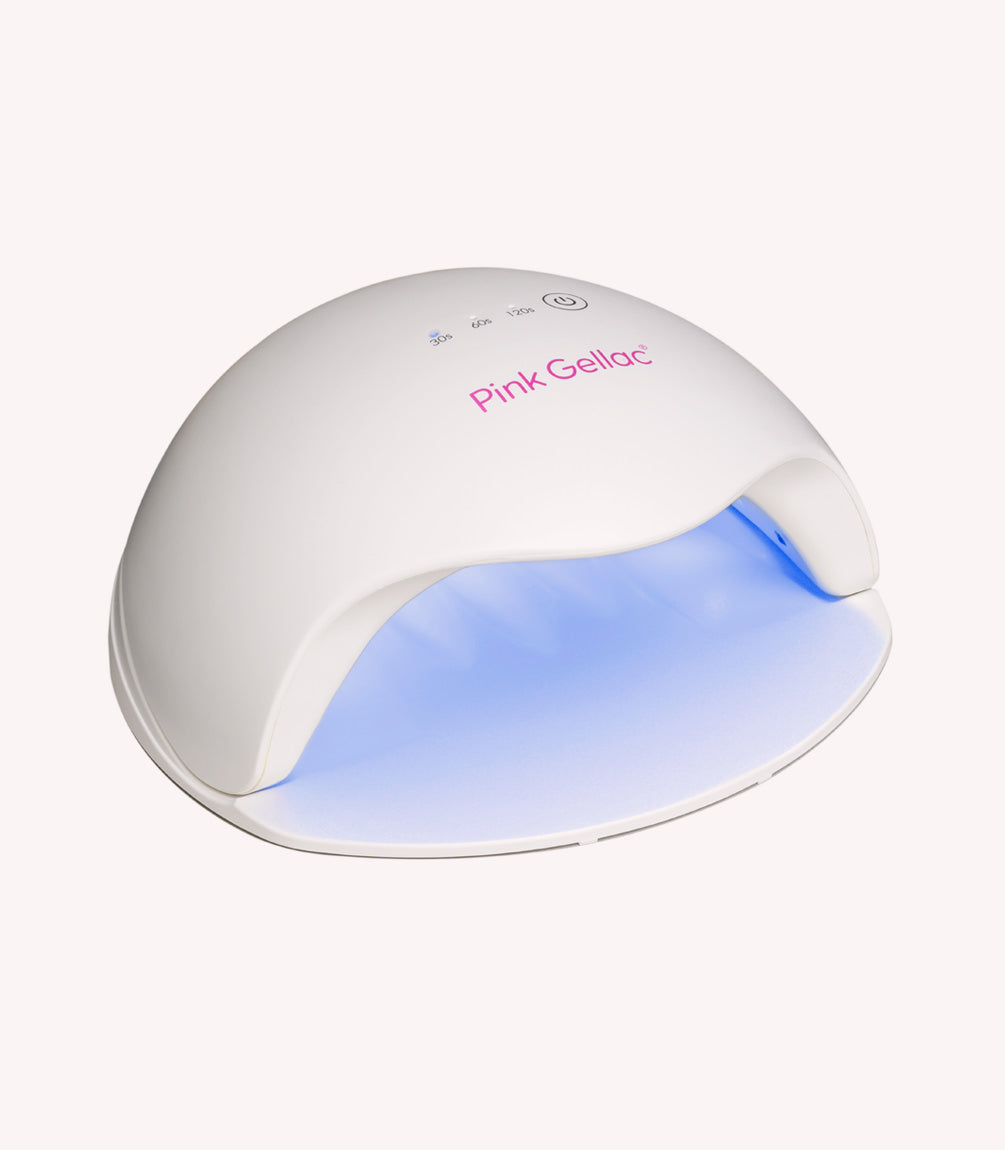 White LED UV lamp for nail drying with pink brand imprint, connected and blue light beams inside.