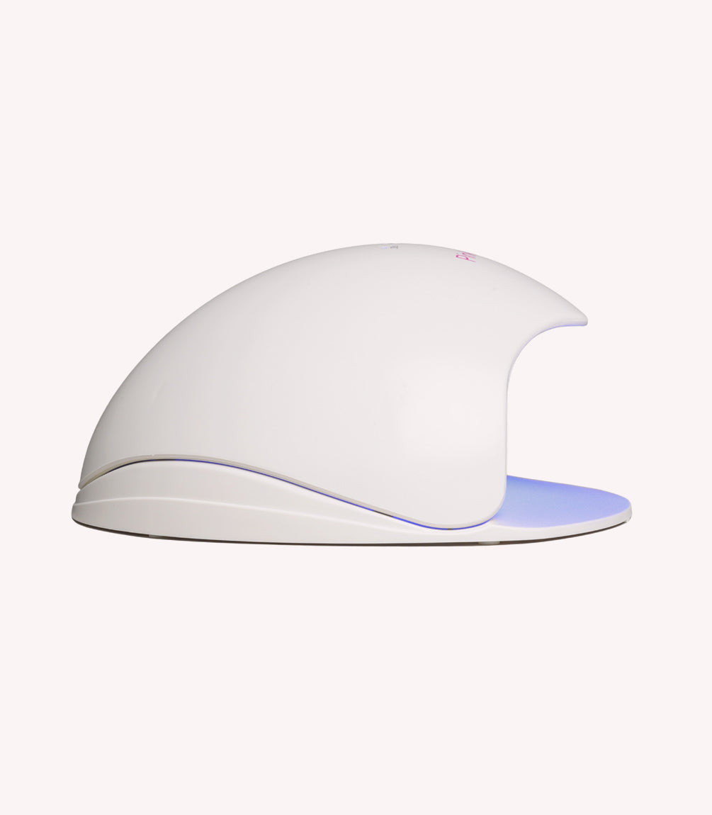 A white LED/UV nail dryer in the shape of a hemisphere with an open front.
