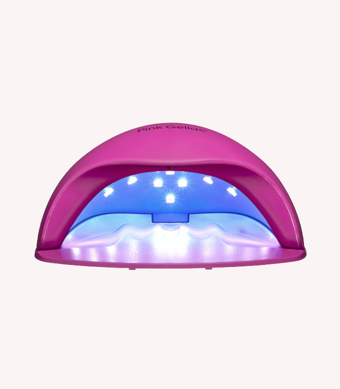 Pink LED nail dryer with lights inside for curing nail polish.
