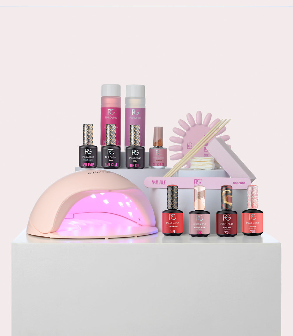 Nail care set with pink LED lamp, nail polish bottles, nail files and accessories.