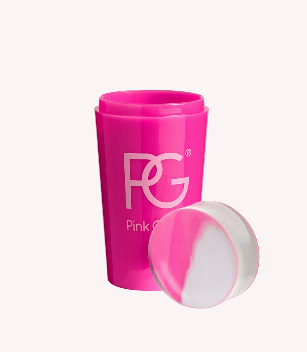 Bright pink cup with the letters "PG" and text "Pink G" on it, next to a round, two-tone white and pink sponge.