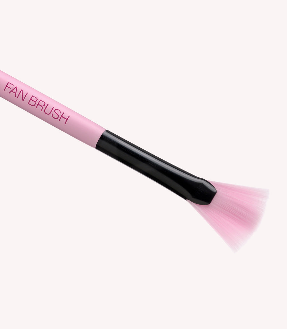 Pink fan makeup brush with black details and pink bristles on a white background.