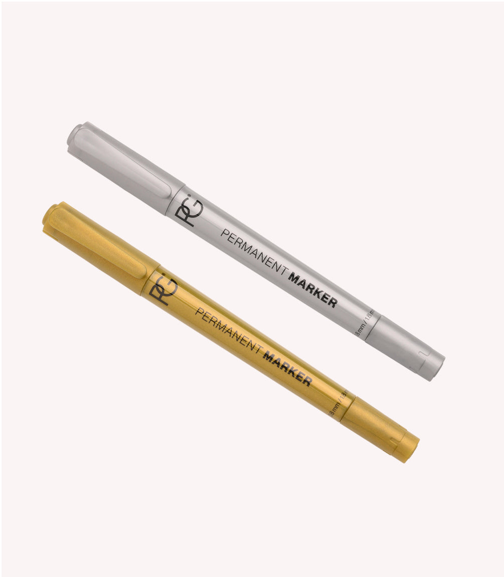Two permanent markers, one©©silver and one©©gold, on a light background.