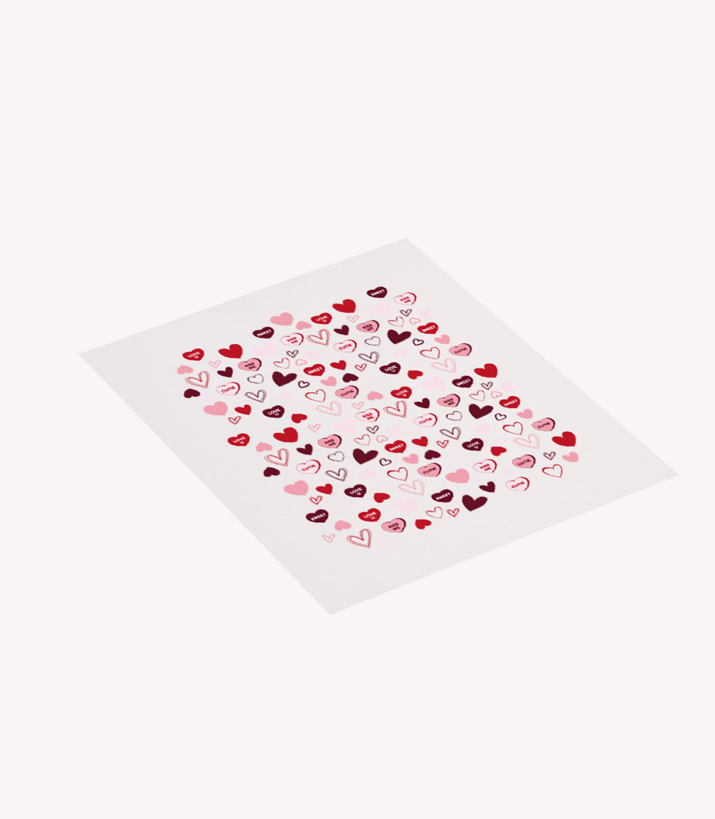 A sheet of paper with a pattern of red, pink and black hearts, some with the word "love".