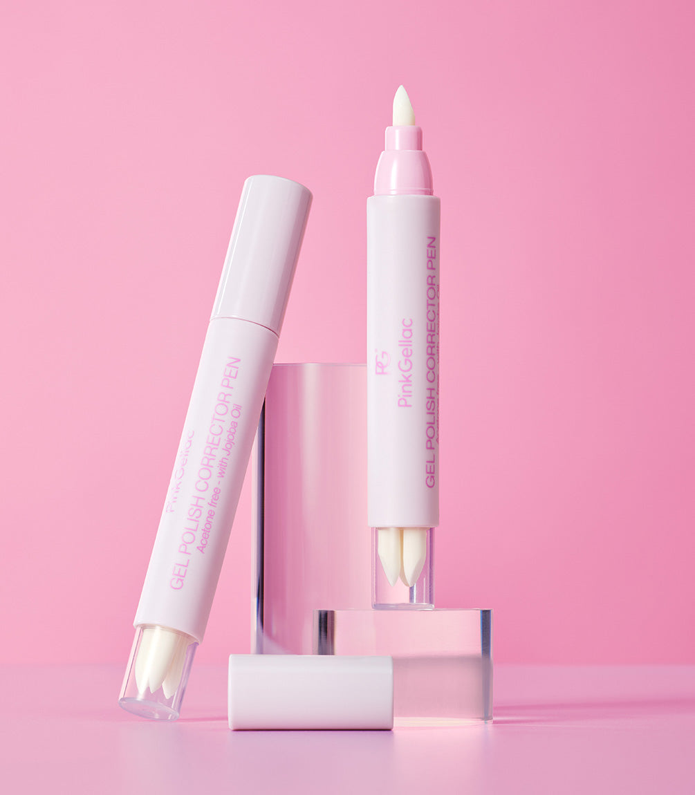 Two gel nail polish correction pens against a pink background, standing on a transparent cube.