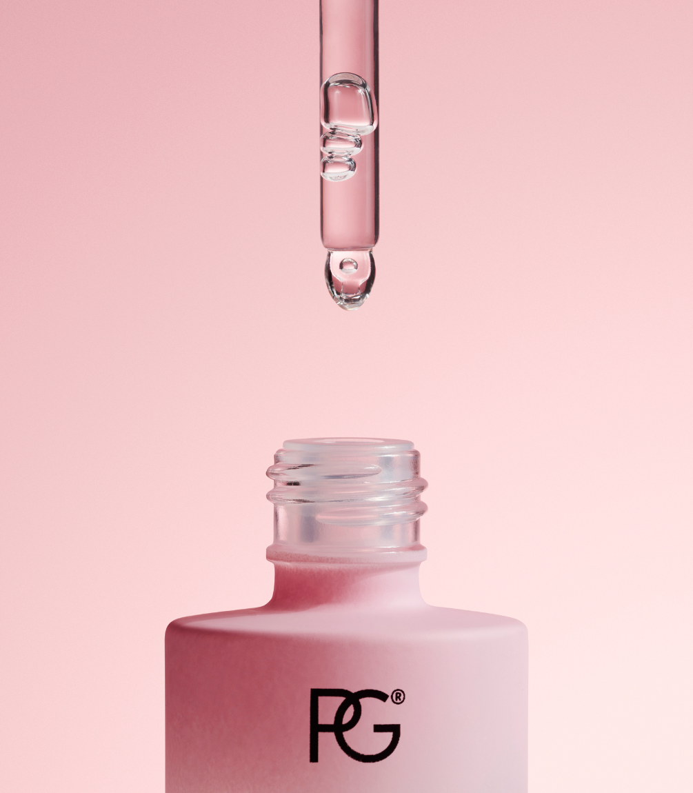 A pink bottle with a pipette above it, against a pink background.