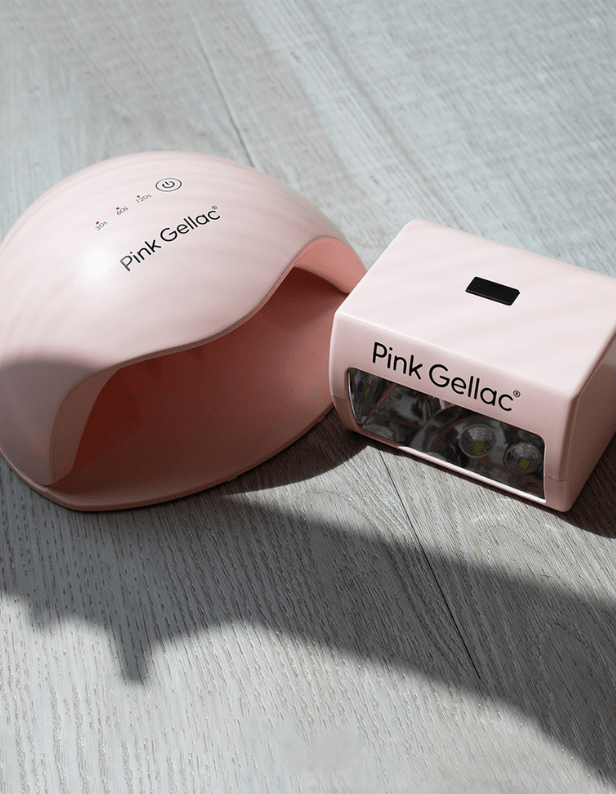 Two pink nail lamps from Pink Gellac on a wooden surface.