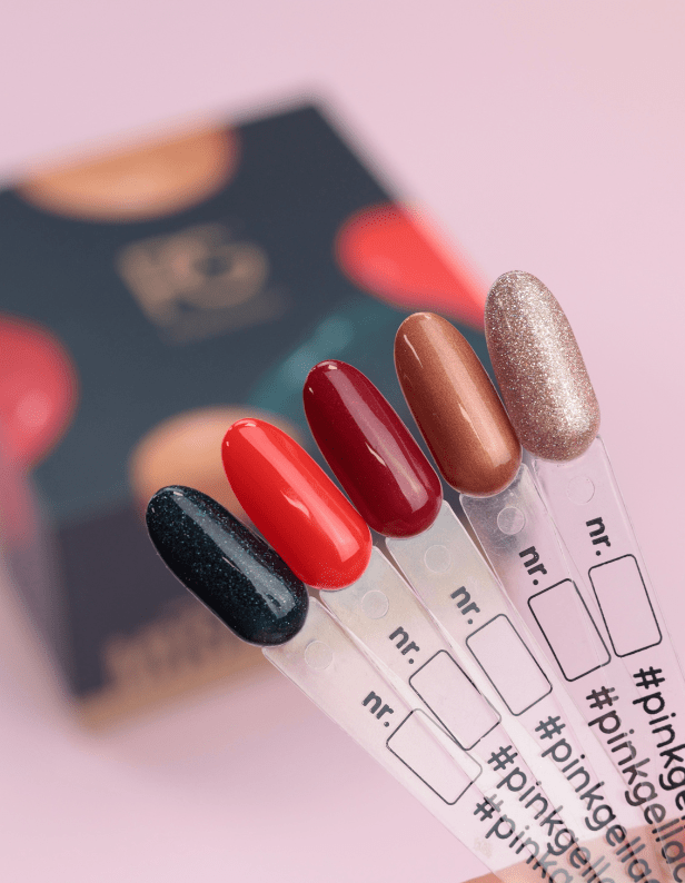 A display with five different colors of nail polish samples on plastic sticks, including black with glitter, bright red, dark red, bronze and shiny pink.