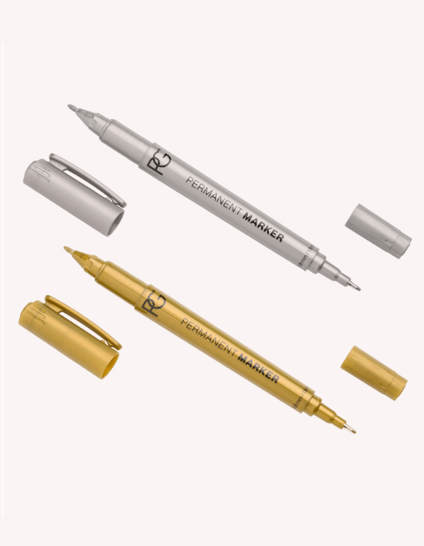 Two permanent markers with removable caps, one©©silver and one©©gold, lie diagonally on a white background.