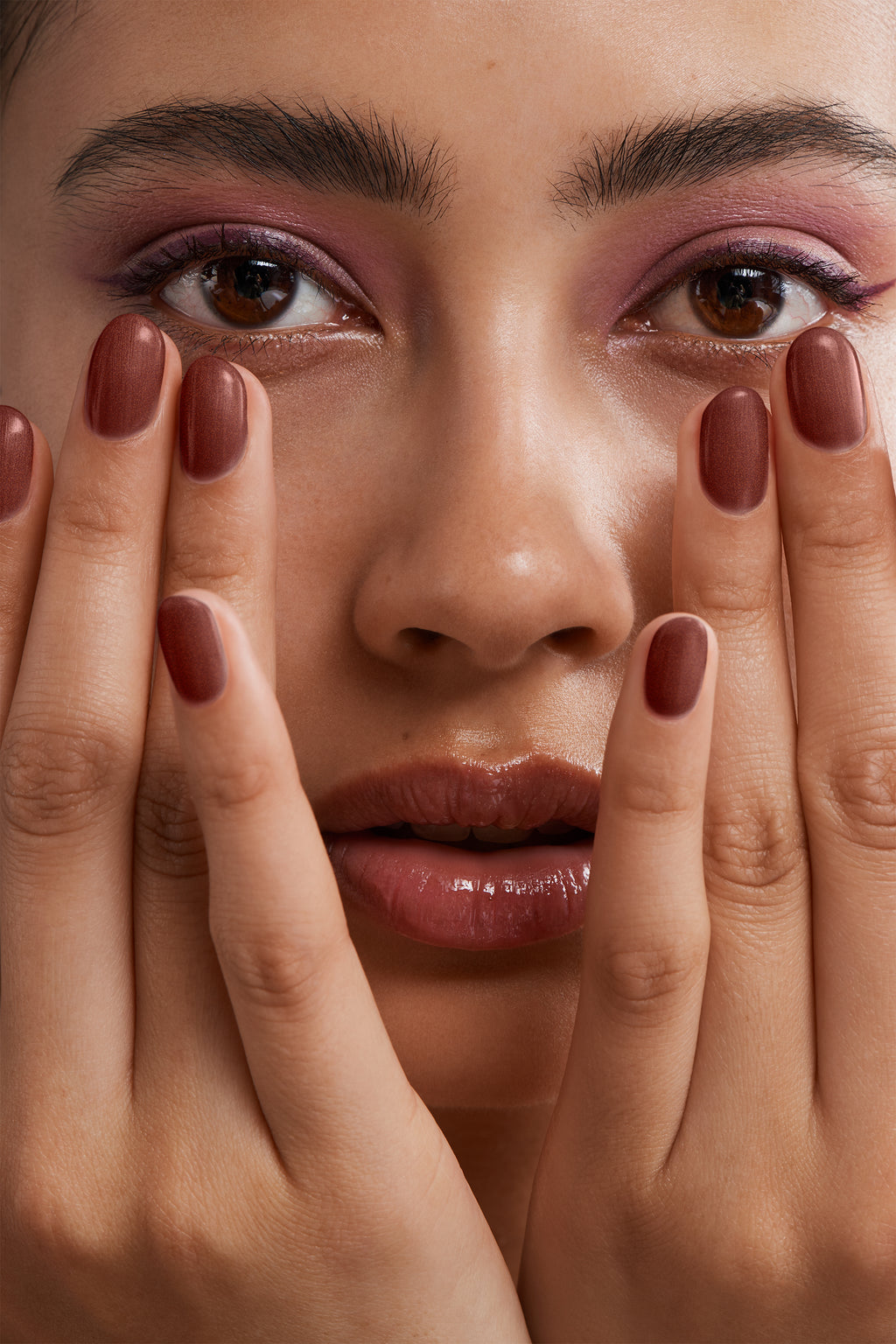 Close-up of a woman with Pink Gellac 150 Chestnut Brown manicured nails near her face.