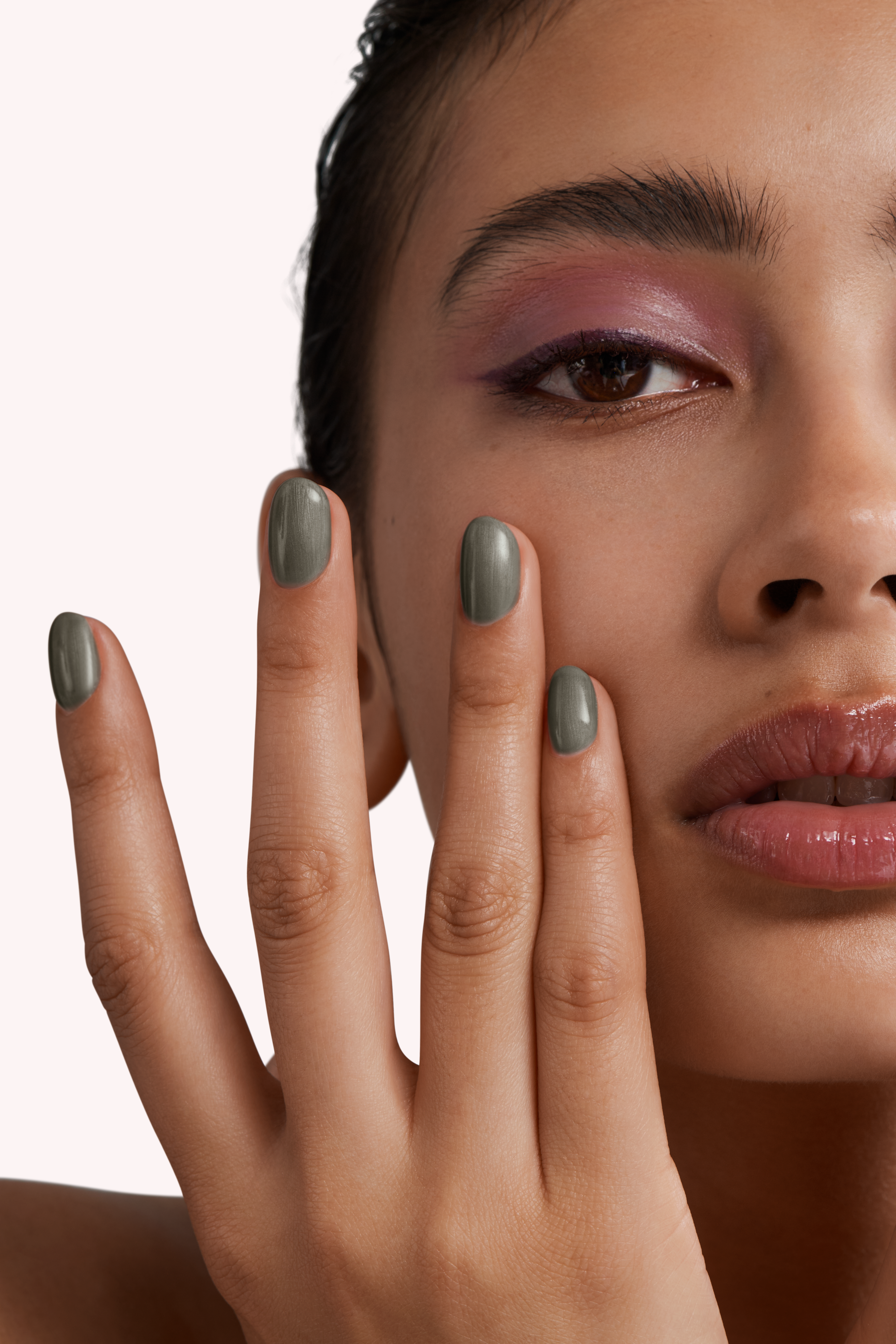 Close-up of a woman with Pink Gellac 153 Petrol Grey manicured nails near her face.