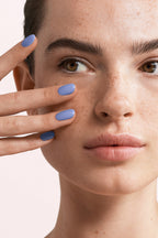 Close-up of a woman with Pink Gellac 157 Sky Blue manicured nails near her face.