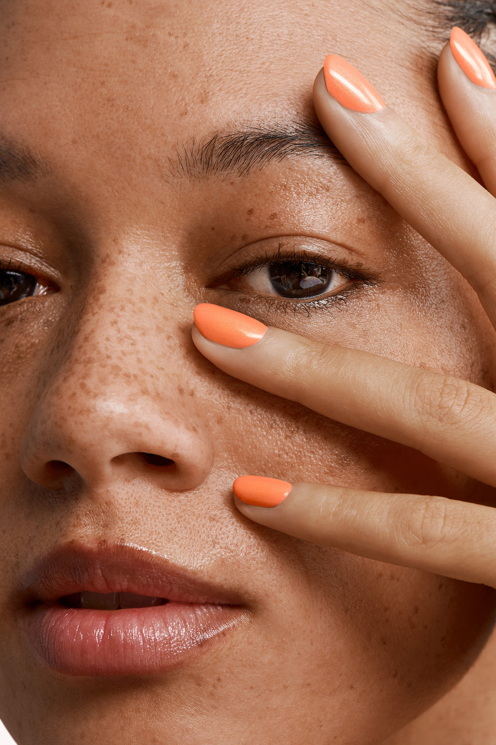 Close-up of a woman with Pink Gellac 159 Glamorous Peach manicured nails near her face.