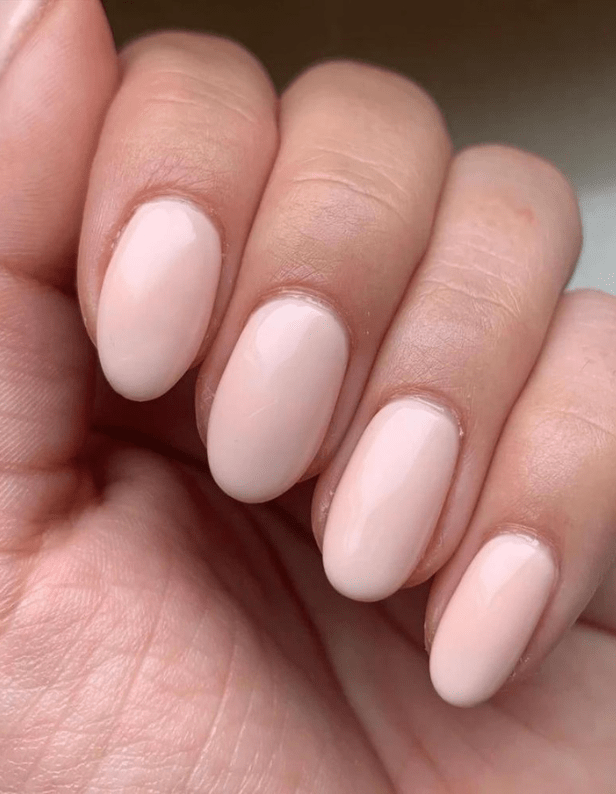 A hand with almond-shaped nails that are painted nude-pink.