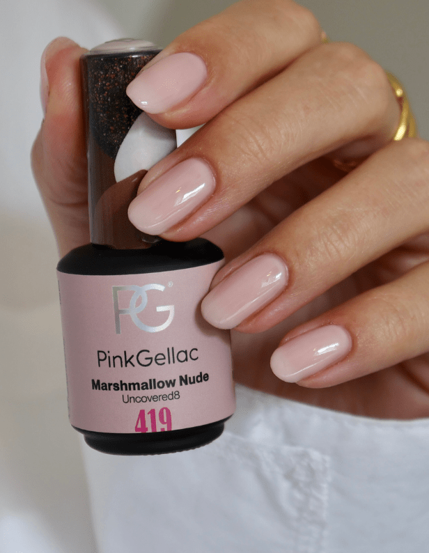Hand with light pink nail polish holds a bottle of "Pink Gellac Marshmallow Nude 419".