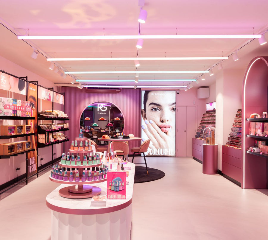 A colorful makeup store with displays of nail polish, cosmetics and a large advertising poster on the back wall.