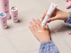 Hand with Pink Gellac 486 Sugarcloud Pink press-on nails on a pink background.