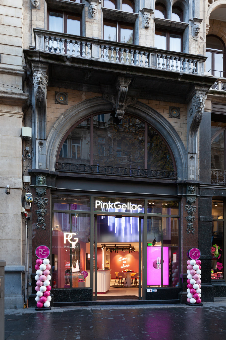 Front view of the Pink Gellac store, with decorations of pink and white balloons at the entrance and an interior with the text "Dare to shine."