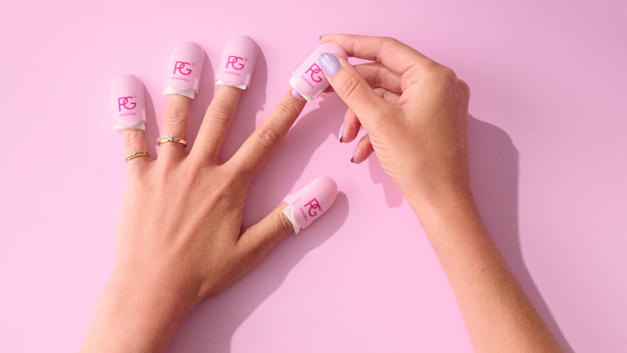 Two hands on a pink background, with one hand placing nail clips in different colors and with a logo on the other fingers.