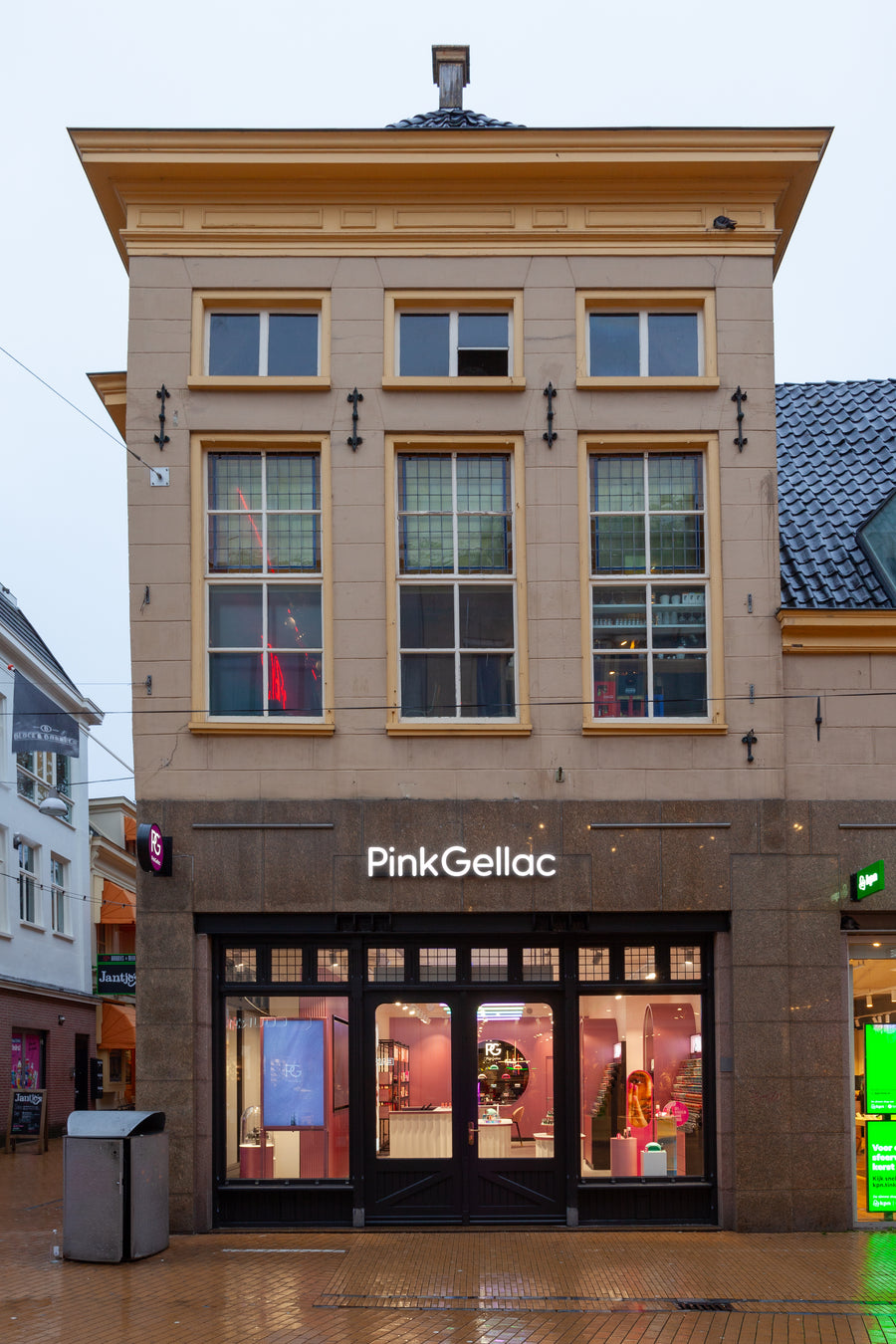 Façade of a shop with the name "Pink Gellac" on it, located on a wet street with a classic look.